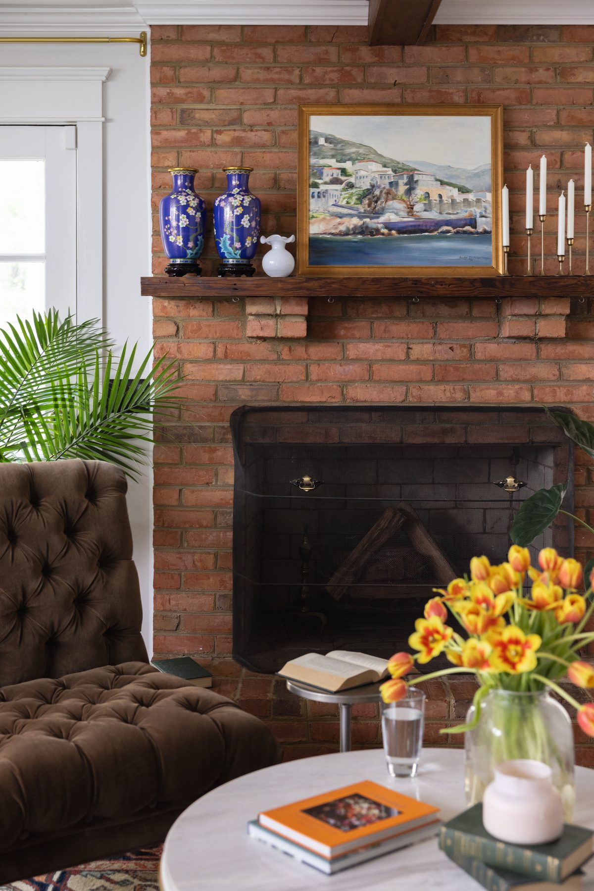 The homeowner arranging the built-in bookshelves, styled in color order from the family&rsquo;s own collection