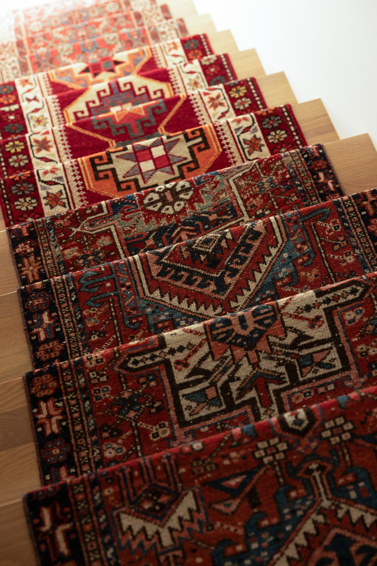 A close view of the stair runner: multiple vintage Persian and Turkish rugs joined into a single patchwork climbing the treads